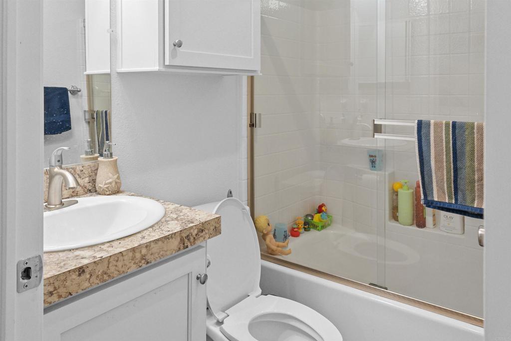 3221 Bancroft Drive, Unit 25 Spring Valley, CA 91977 - Photo 9 of 17 a bathroom with a granite countertop toilet sink and mirror