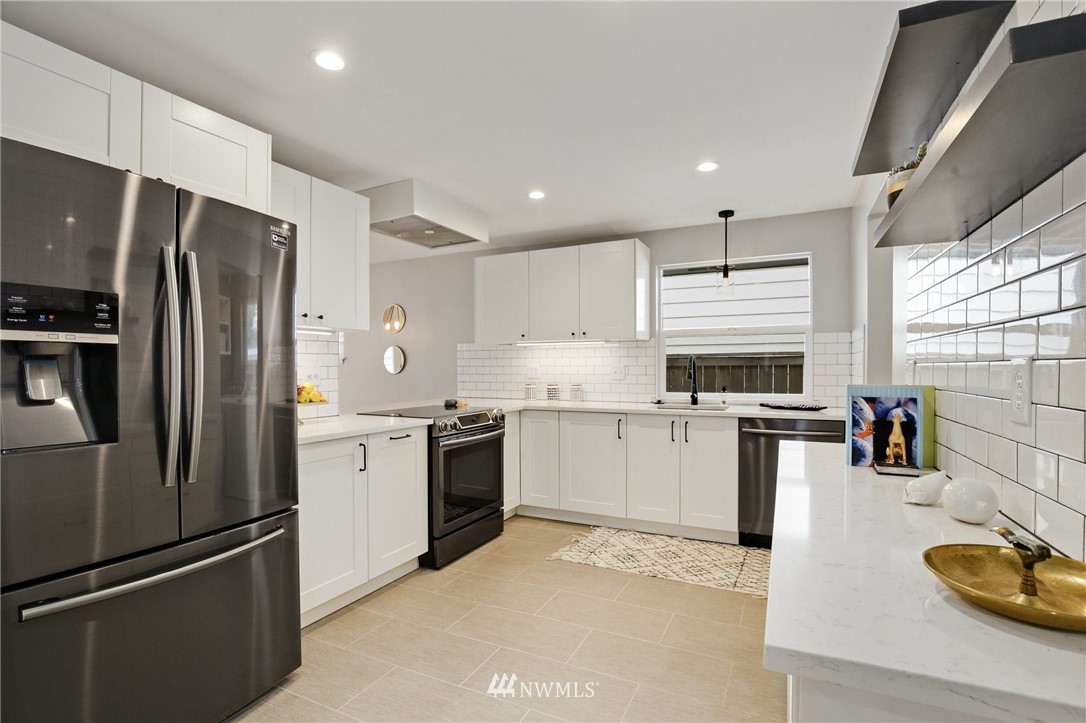 10014 40th Avenue Southwest Seattle, WA 98146 - Photo 11 of 36 a kitchen with a refrigerator and a stove top oven