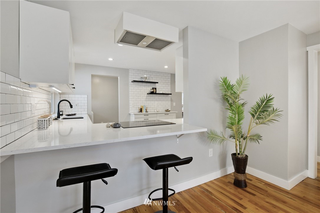 10014 40th Avenue Southwest Seattle, WA 98146 - Photo 13 of 36 a kitchen with a potted plant on the counter and cabinets