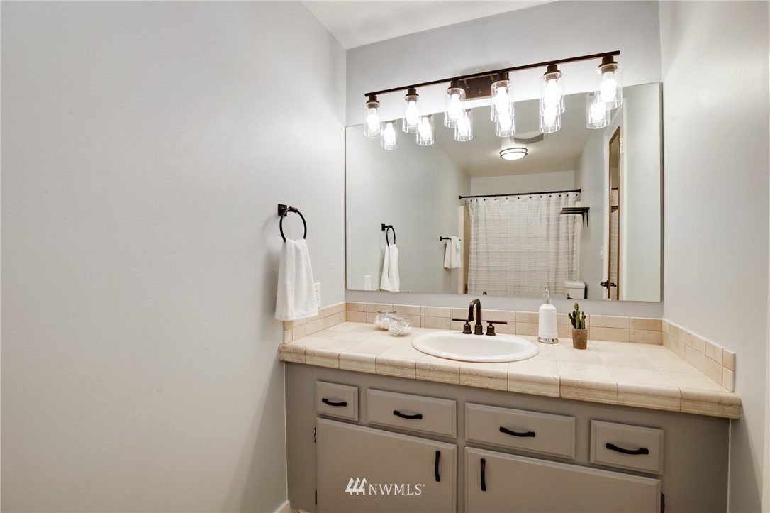 10014 40th Avenue Southwest Seattle, WA 98146 - Photo 23 of 36 a bathroom with a sink and a mirror