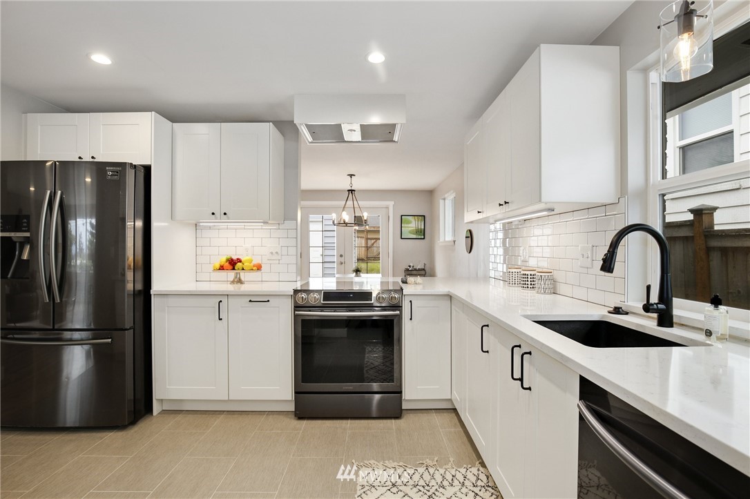 10014 40th Avenue Southwest Seattle, WA 98146 - Photo 9 of 36 a kitchen with stainless steel appliances a refrigerator sink and white cabinets