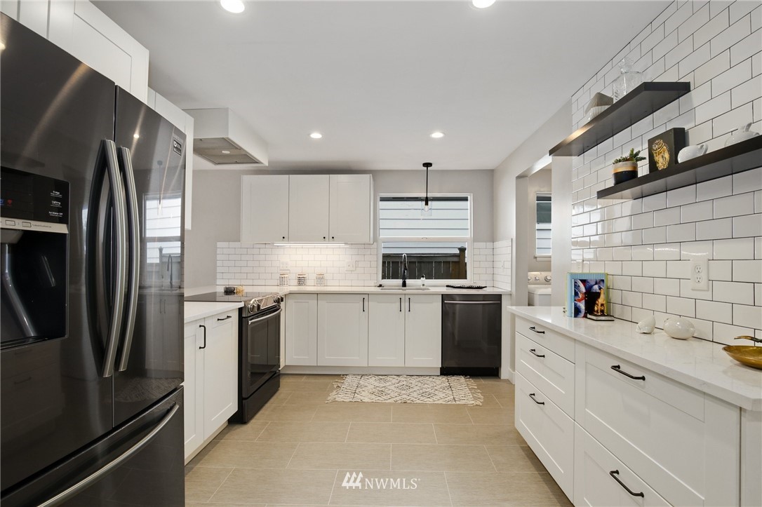 10014 40th Avenue Southwest Seattle, WA 98146 - Photo 10 of 36 a kitchen with a sink stainless steel appliances and cabinets