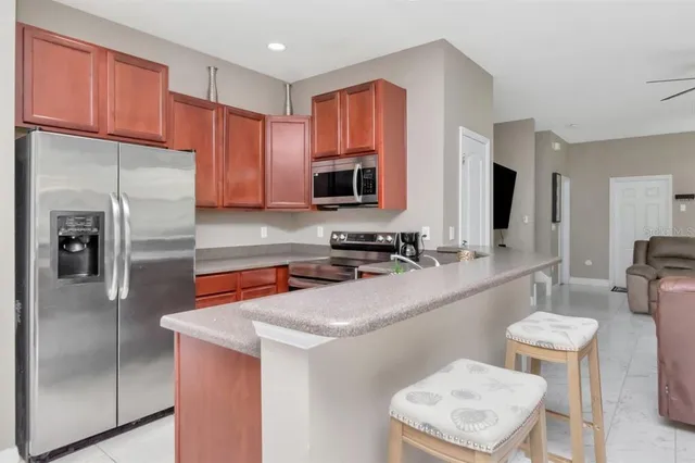 a kitchen with stainless steel appliances granite countertop a refrigerator a sink and a cabinets
