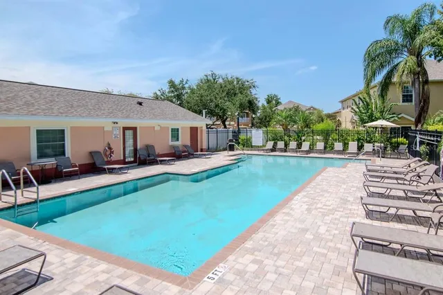 a view of a house with swimming pool and sitting area