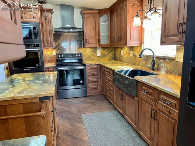 a kitchen with stainless steel appliances granite countertop a stove a sink and a microwave