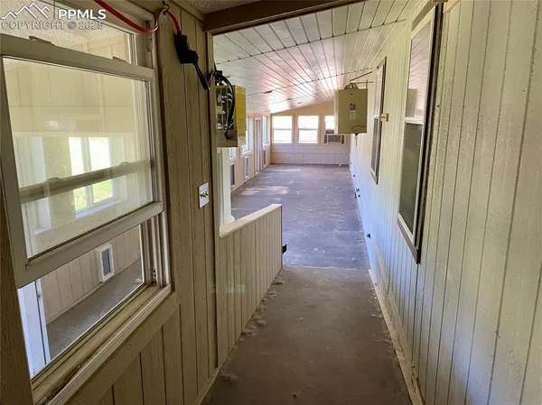a view of a hallway with wooden floor and windows