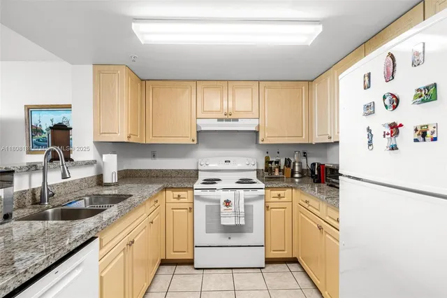 a kitchen with granite countertop white cabinets and white appliances