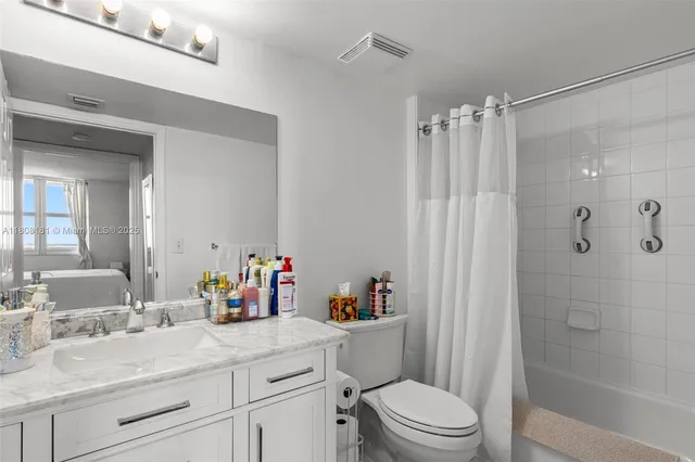 a bathroom with a sink vanity mirror and toilet
