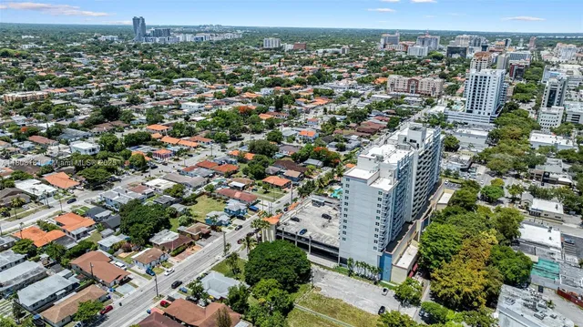 an aerial view of a house with a yard and large tree