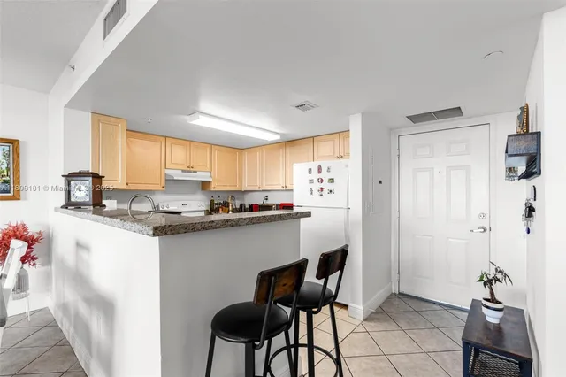 a kitchen with stainless steel appliances granite countertop a sink and a refrigerator