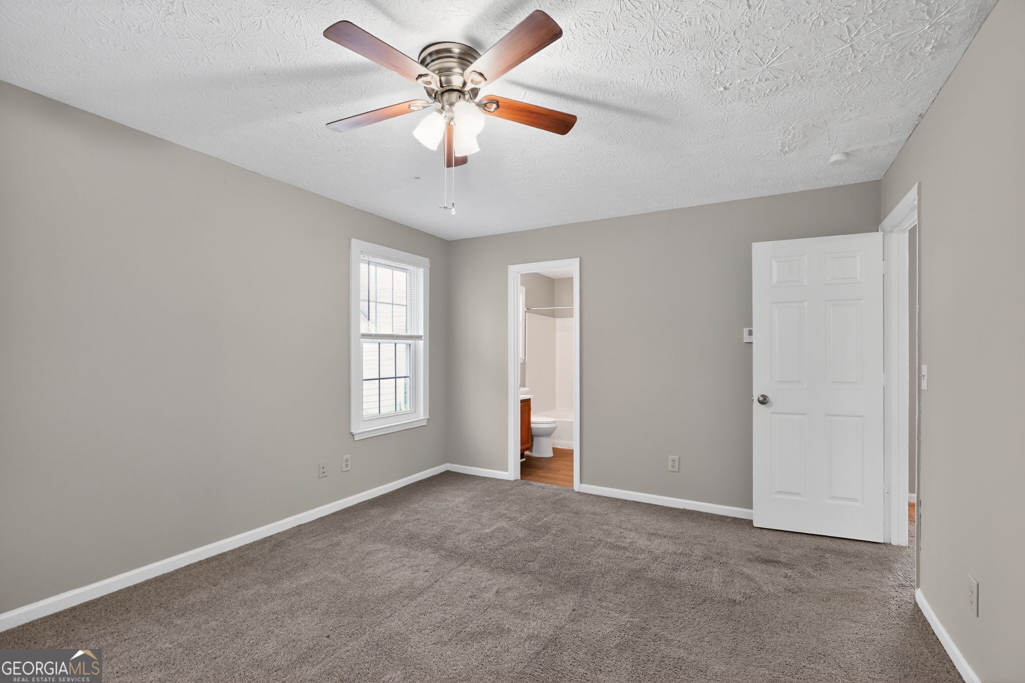 3751 Oakwood Manor Court Decatur, GA 30032 - Photo 29 of 33 an empty room with chandelier fan and windows