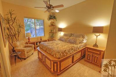 21 Bellisimo Court Rancho Mirage, CA 92270 - Photo 16 of 25 a spacious bedroom with a bed and a chandelier