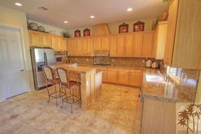 21 Bellisimo Court Rancho Mirage, CA 92270 - Photo 3 of 25 a kitchen with stainless steel appliances a dining table chairs and a refrigerator