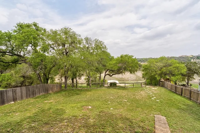 a house view with swimming pool and trees in the background