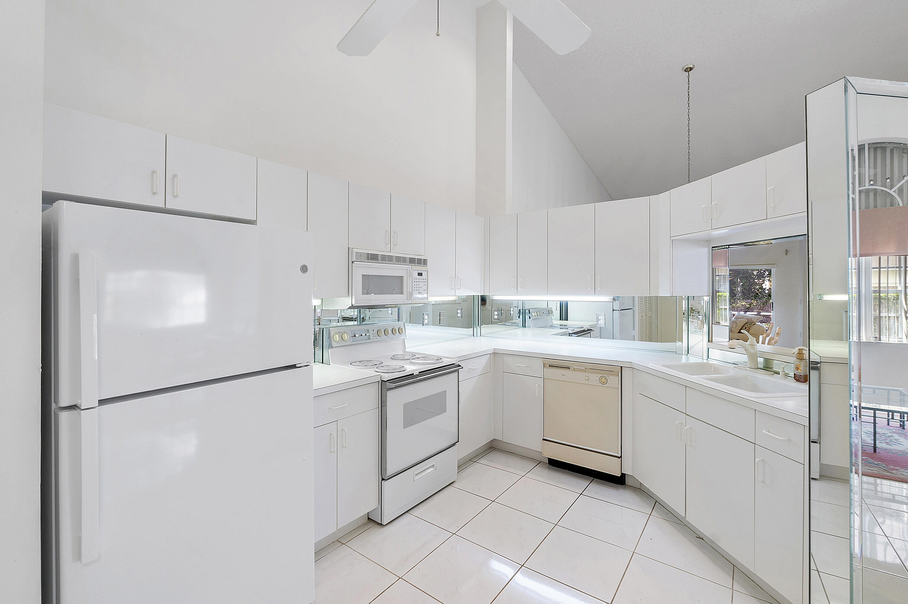 9705 Malvern Drive Tamarac, FL 33321 - Photo 9 of 29 a kitchen with white cabinets and white appliances