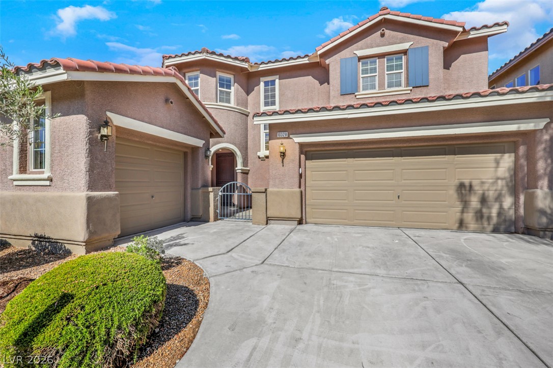 10328 Hawk Ravine Street Las Vegas, NV 89178 - Photo 4 of 55 A spacious driveway and twin garages define this appealing stucco residence.