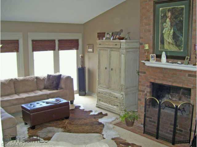 8528 Benbow-Merrill Road Oak Ridge, NC 27310 - Photo 2 of 9 Other. Inviting living room with vaulted ceiling, windows overlooking the lake, and wood-burning fireplace.