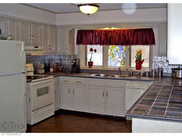 8528 Benbow-Merrill Road Oak Ridge, NC 27310 - Photo 4 of 9 Other. Kitchen with tile counters, refinished cabinets, NEW hardware, sink & nickel faucet, smooth-top range and spacious lakeside dining area with access to upper deck. O sized laundry rm off kit.