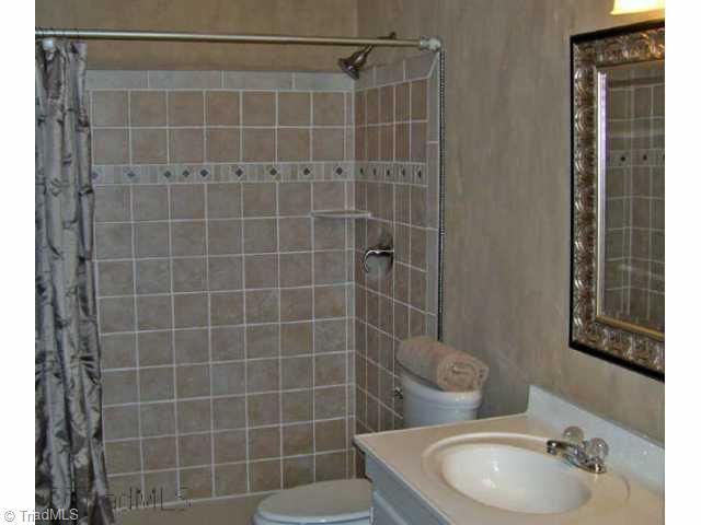 8528 Benbow-Merrill Road Oak Ridge, NC 27310 - Photo 5 of 9 Other. Renovated lower bath with dual sinks and earthtone tiled, o sized shower