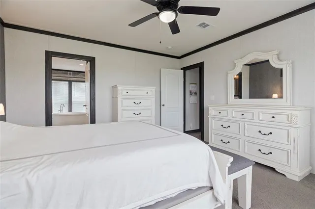 a bedroom with a bed a window and a flat screen tv