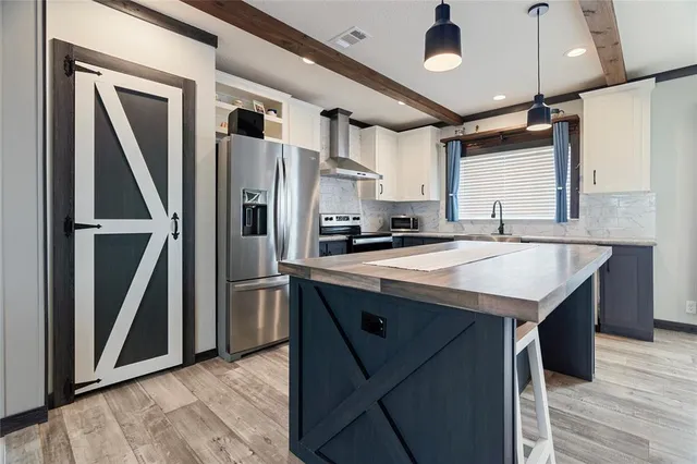 a kitchen with stainless steel appliances granite countertop a refrigerator a sink and a stove