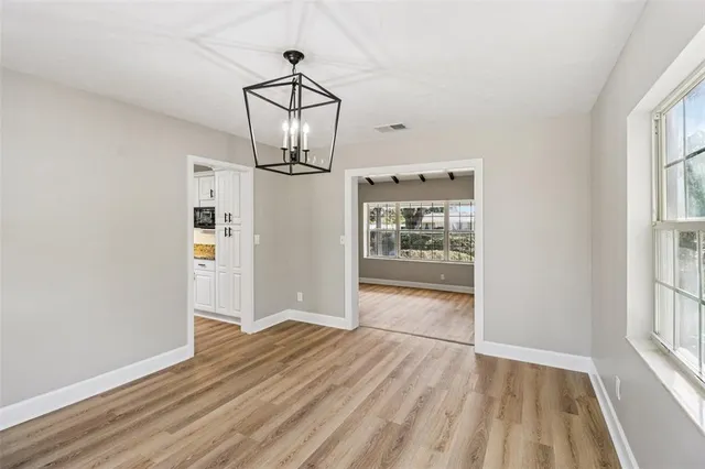 an empty room with a window and a ceiling fan