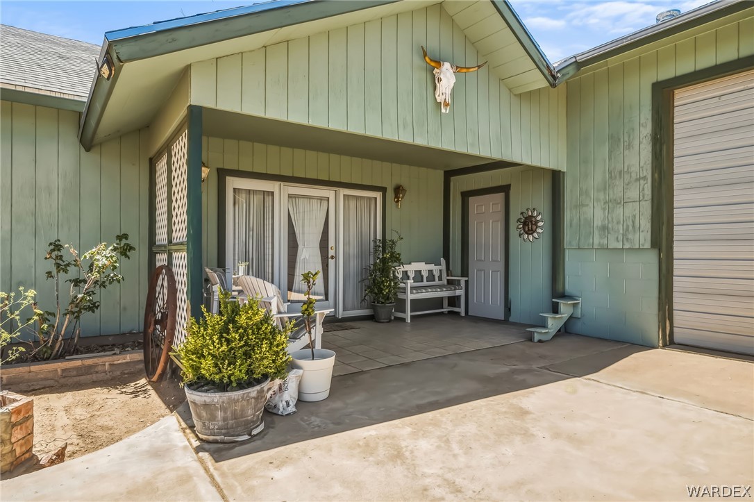 2401 North Stephan Road Kingman, AZ 86401 - Photo 14 of 92 Covered patio area featuring a concrete slab, a white entry door, and double glass paneled doors