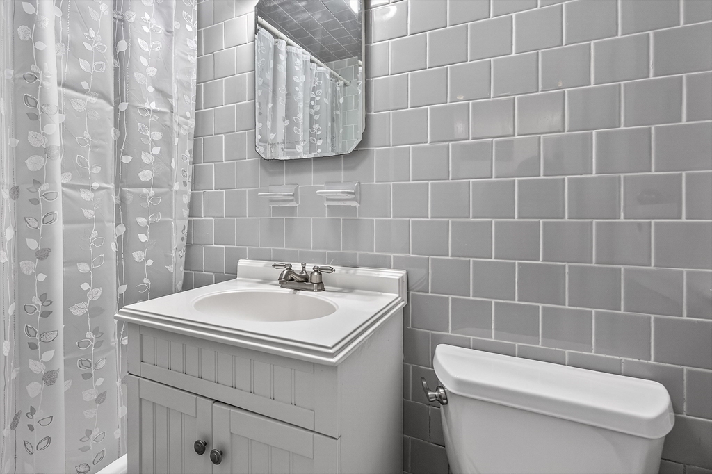 64 Commonwealth Avenue, Unit G1 Boston, MA 02116 - Photo 11 of 12 a bathroom with a toilet sink and mirror