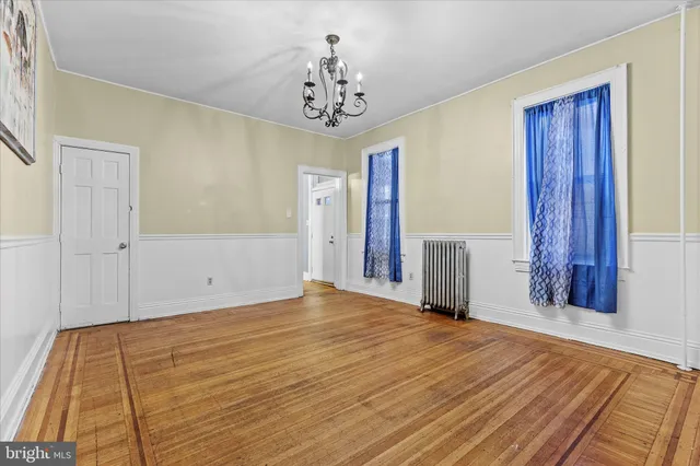a view of a room with wooden floor and a chandelier