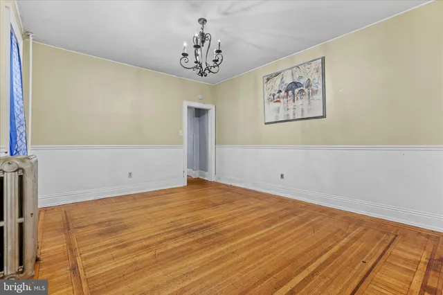 a view of a room with wooden floor and a bookshelf