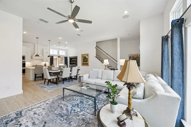 a living room with furniture kitchen view and a chandelier
