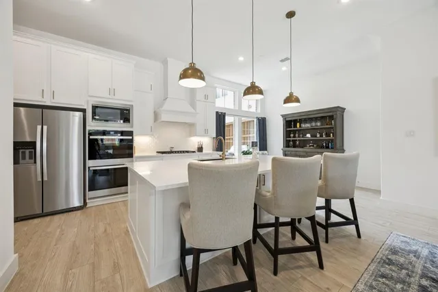 a living room with furniture kitchen view and a wooden floor