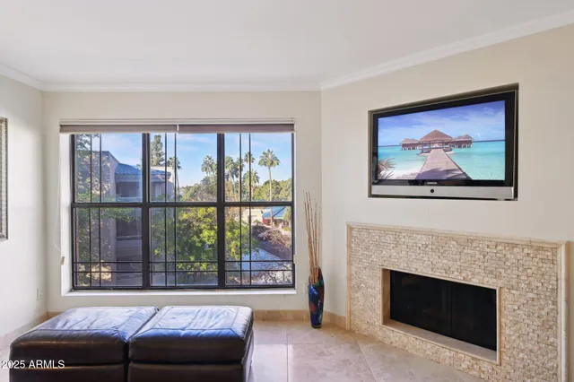 a living room with furniture a fireplace and a large window