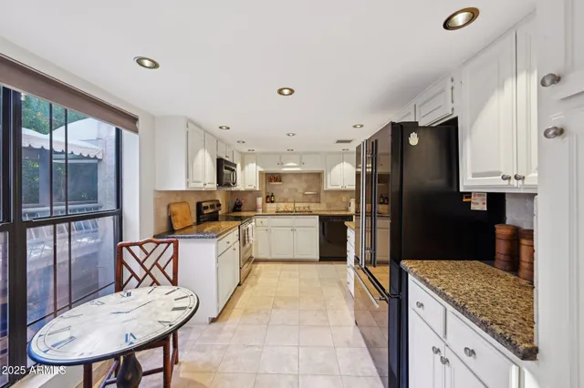 a kitchen with stainless steel appliances granite countertop a refrigerator and a sink