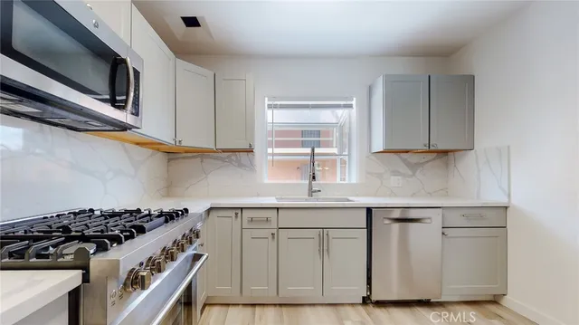a kitchen with white cabinets stainless steel appliances and sink