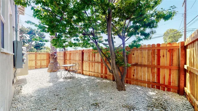 an entrance to house with yard and tree