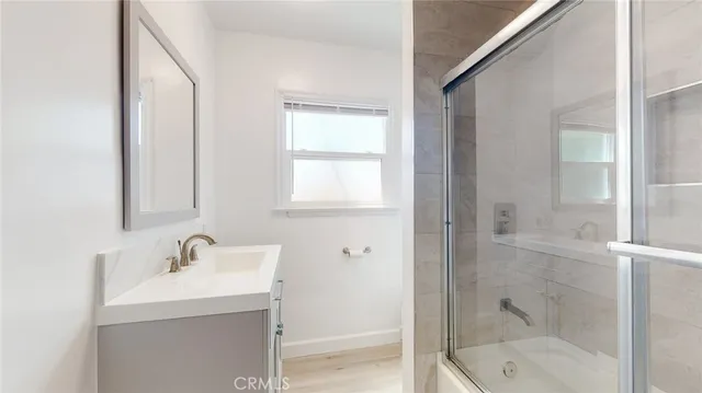 a bathroom with a shower sink and mirror