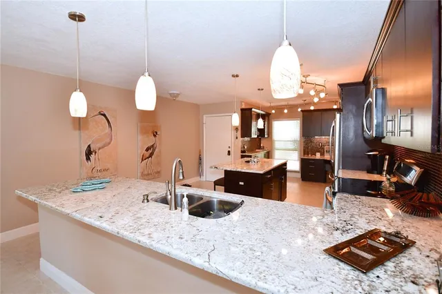 a kitchen with a sink a stove and chairs