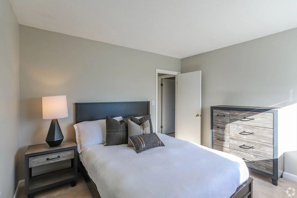 8 Lakeview Gardens, Unit 8 Natick, MA 01760 - Photo 11 of 15 a bedroom with a bed and a night stand