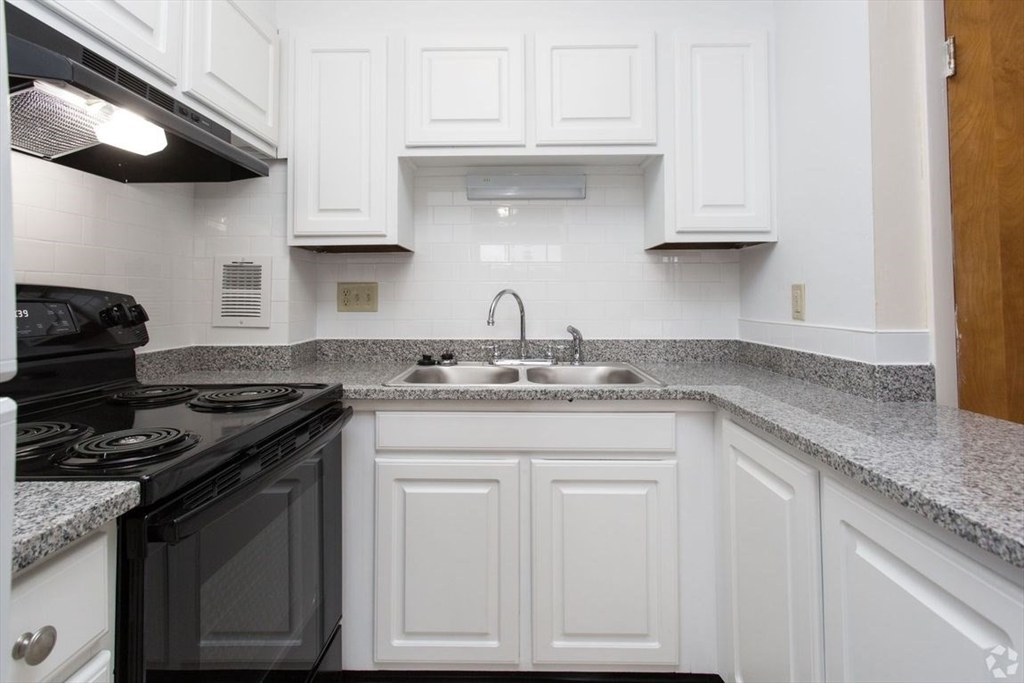 8 Lakeview Gardens, Unit 8 Natick, MA 01760 - Photo 7 of 15 a kitchen with stainless steel appliances granite countertop white cabinets and a stove