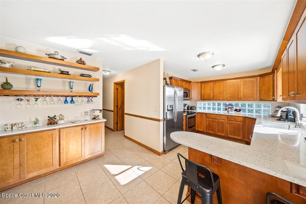 145 Richards Road Melbourne Beach, FL 32951 - Photo 21 of 53 a kitchen with stainless steel appliances granite countertop a sink and a refrigerator