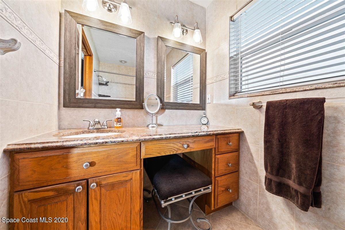 145 Richards Road Melbourne Beach, FL 32951 - Photo 33 of 53 a bathroom with a sink a mirror and a window