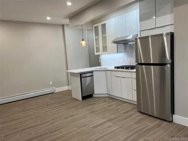 a kitchen with stainless steel appliances a refrigerator and wooden floor