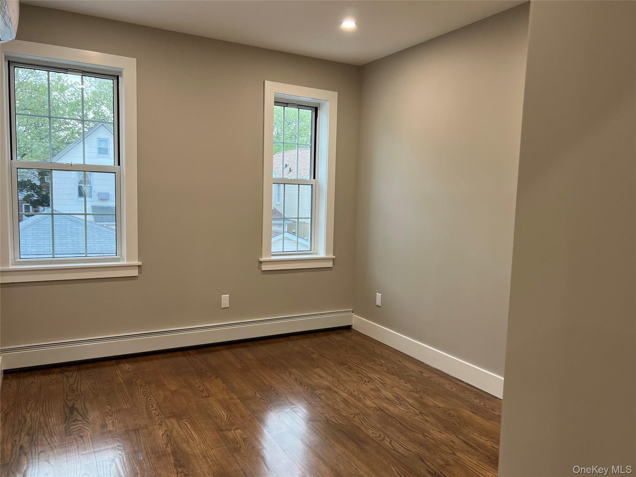89-21 69th Road, Unit 2R Queens, NY 11375 - Photo 4 of 16 an empty room with wooden floor and windows
