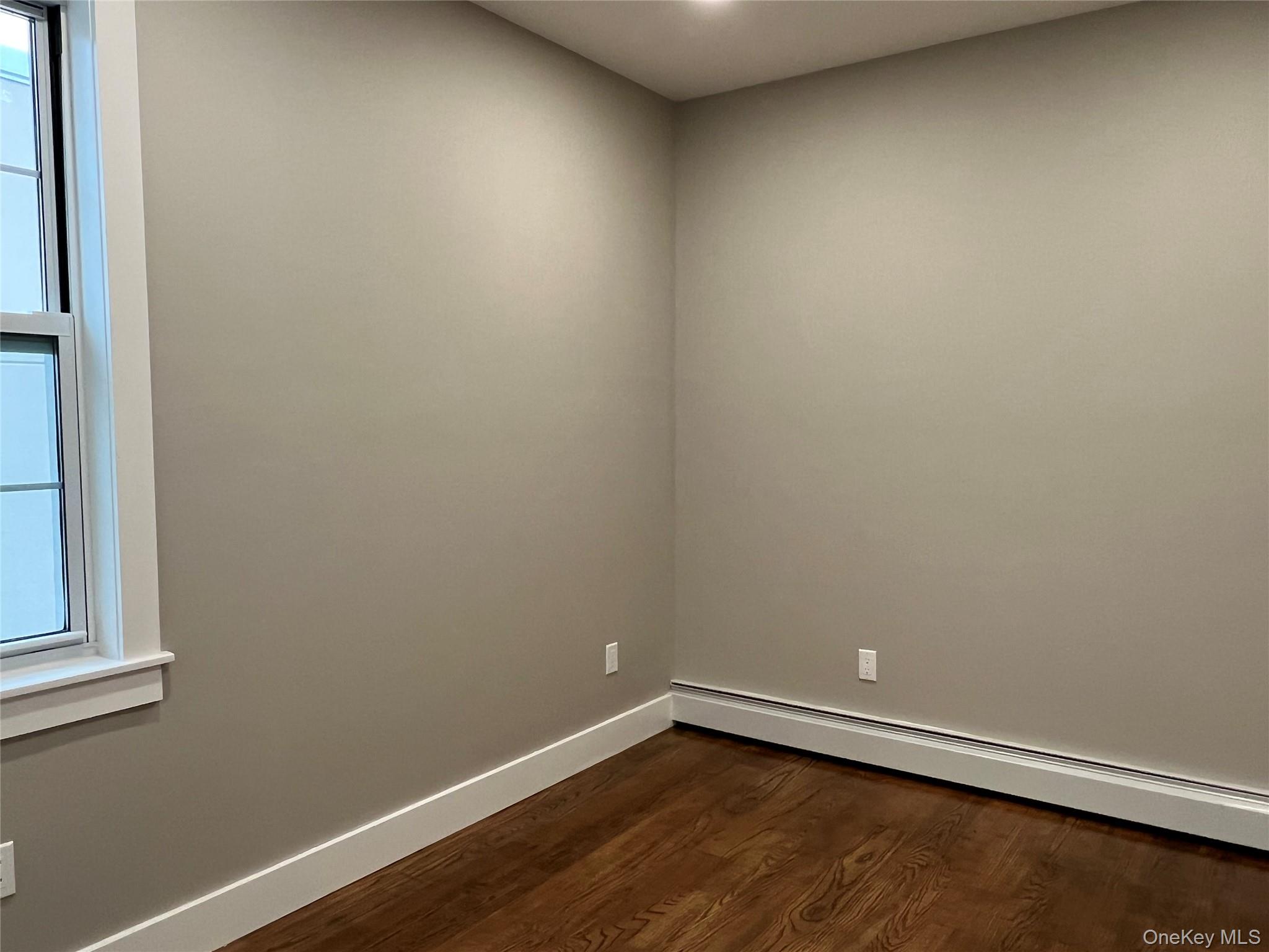 89-21 69th Road, Unit 2R Queens, NY 11375 - Photo 7 of 16 a view of an empty room with wooden floor and a window