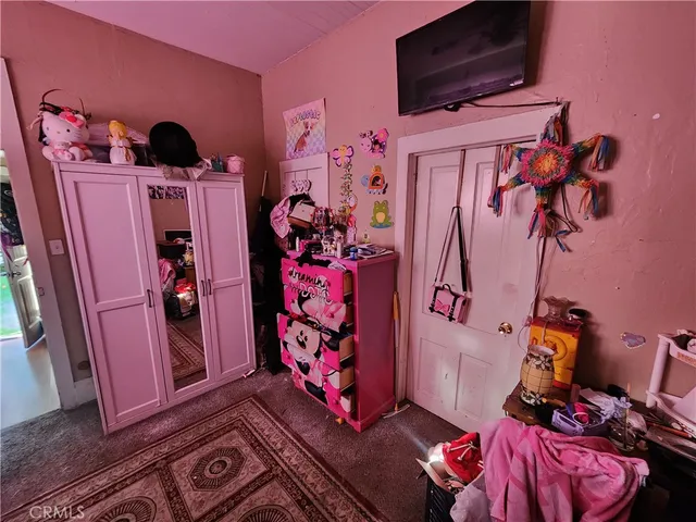 a bedroom with a bed window and a television