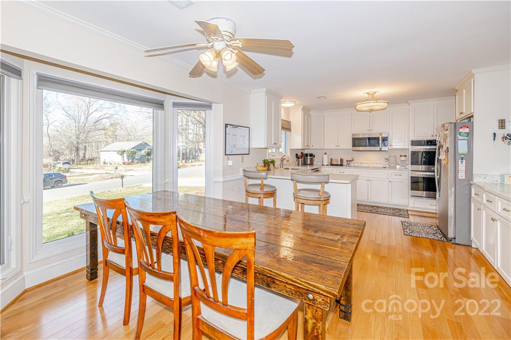 5100 Rounding Run Road Charlotte, NC 28277 - Photo 8 of 46 a dining room with furniture a chandelier and wooden floor