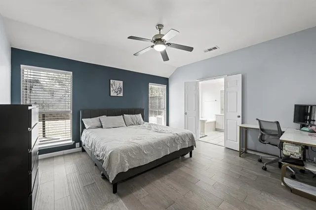 a bedroom with a large bed and a chandelier