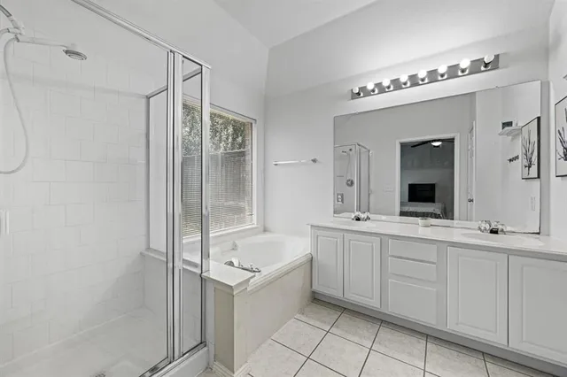 a bathroom with a double vanity sink mirror and a bathtub