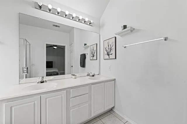 a bathroom with a double vanity sink and mirror